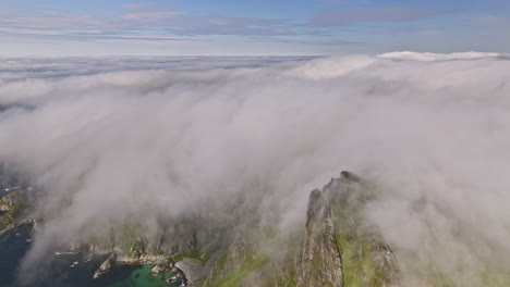 Stave-Norway-v18-cinematic-pristine-landscape-view,-drone-fly-around-måtind-summit-viewpoint-capturing-craggy-mountain-ridges-covered-in-thick-layer-of-white-fog---Shot-with-Mavic-3-Cine---June-2022