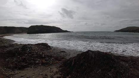 Slow-motion-Anglesey-ocean-waves-splashing-around-large-rock-shoreline