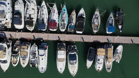 Sailing-boats-and-luxury-yachts-moored-at-port,-aerial-overhead-view