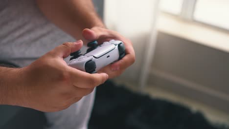 Close-up-of-male-hands-playing-video-game-by-a-open-window-light-in-slow-motion