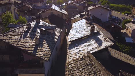 Establishing-drone-shot-of-a-small-town-on-the-italian-alps,-aerial-view-on-a-sunny-day