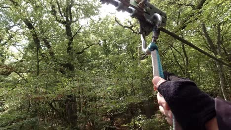Hands-Attaching-Carabiner-And-Trolley-On-Zipline-Rope-In-The-Forest