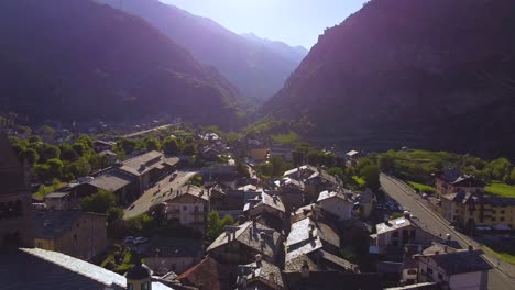 Italian-alps-village-on-a-sunny-day,-aerial-drone-view-with-backward-motion