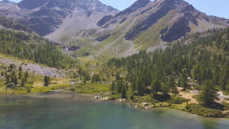 Establishing-drone-shot-of-big,-rocky-mountains-next-to-a-lake-on-the-italian-alps