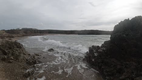 Slow-motion-Anglesey-ocean-waves-splashing-around-large-rock-coastline