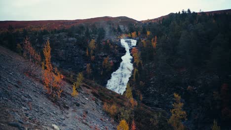 Waterfall-Flowing-Down-Through-Rocky-Mountains-In-Dovrefjell,-Norway-During-Autumn