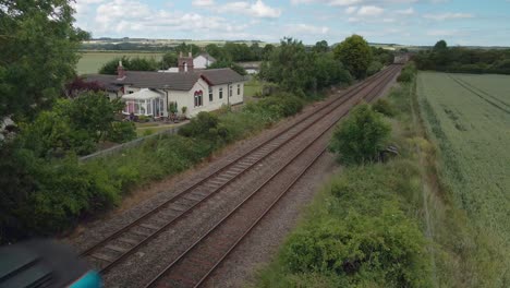 Aerial-view-of-a-train-passing-on-tracks-in-the-countryside-in-England