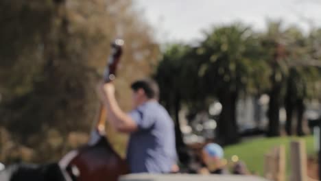 Blurred-shot-of-musician-playing-the-cello-in-a-park-during-daytime-and-sunshine-weather
