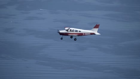 Avión-Piper-Pa-28-Cherokee-Volando-Sobre-El-Mar-Azul,-Toma-Aire-aire