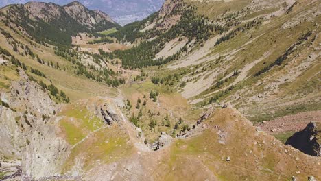 Establishing-shot-of-a-valley-on-the-italian-alps-with-yellowish-green-vegetation