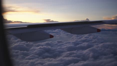 Airplane-is-flying-above-the-clouds,-view-from-the-window-on-the-wing