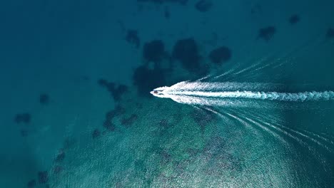 Motorboat-leaves-wave-trail-in-blue-ocean,-aerial-view-from-above