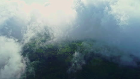 Aerial-flight-through-dense-clouds-at-sky-with-green-valley-in-summer