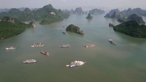 aerial-of-cruise-ships-anchored-in-Ha-Long-Bay-around-limestone-mountain-rocks-on-sunny-morning-in-Vietnam