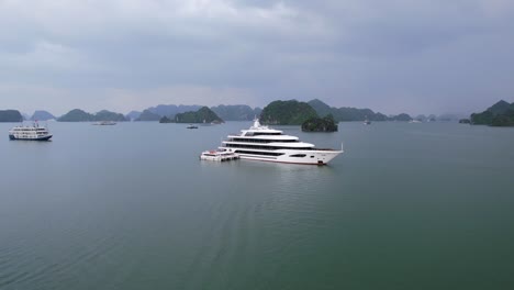 Luftschwenk-über-Den-Bug-Einer-Weißen-Luxusyacht-In-Ha-Long-Bay-Vietnam,-Umgeben-Von-Tropischem-Wasser