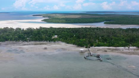 aerial-zoom-out-of-pier-on-leebong-island-on-hot-summer-day-at-low-tide-Belitung-Indonesia