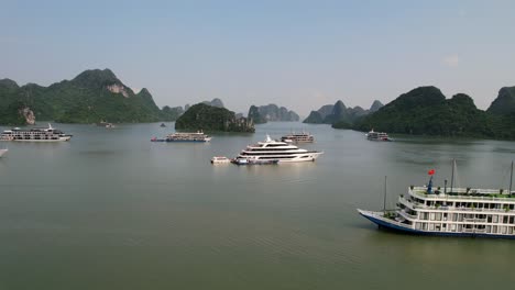 Zoom-Aus-Der-Luft-Aus-Einem-Traditionellen-Vietnamesischen-Kreuzfahrtschiff,-Das-Bei-Sonnenaufgang-Mit-Touristen-In-Ha-Long-Bay-Vietnam-Reist