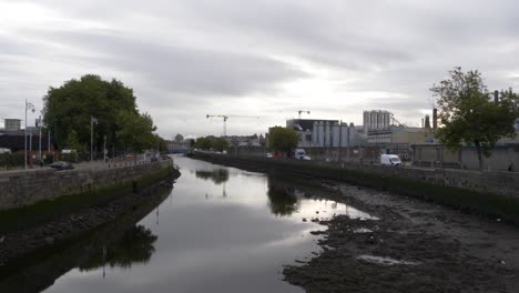 Shallow-Water-Of-Liffey-River-With-Guinness-Brewery-Plant-In-The-Background