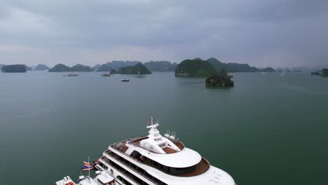 aerial-flying-over-white-luxury-mega-yacht-in-Ha-Long-Bay-Vietnam-on-cloudy-day