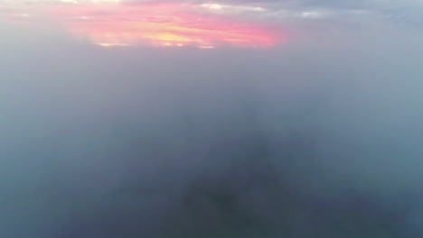 Aerial-drone-forward-moving-shot-flying-through-fluffy-white-clouds-along-colorful-sky-during-evening-time