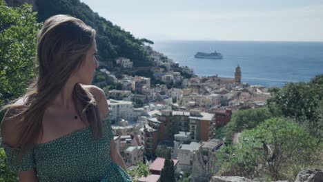 Front-View-Of-A-Gorgeous-Woman-At-Viewpoint-In-Amalfi-Coast-Overlooking-Mediterranean-Coastline-And-Seascape-In-Italy