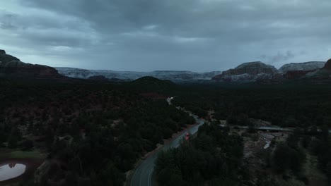 Road-With-Vehicles-Traveling-In-Sedona,-Arizona-On-A-Cloudy-Sunset---aerial-drone-shot