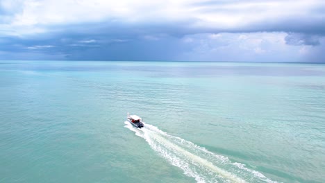 A-bird's-eye-view-of-speedboat's-wake-in-blue-sea-with-cloudy-sky-background