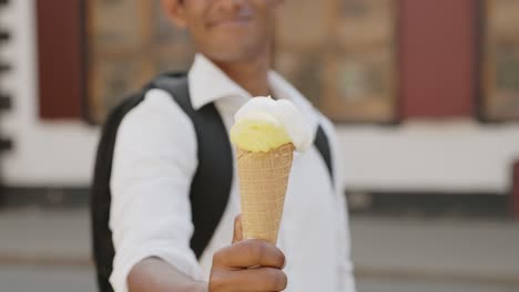Classy-man-holding-and-giving-ice-cream-on-hot-summer-day,-sharing-is-caring