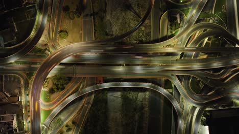 Aerial-Motion-time-lapse-above-cars-in-a-lit-intersection,-nigttime-in-Mexico---Birds-eye,-drone-shot