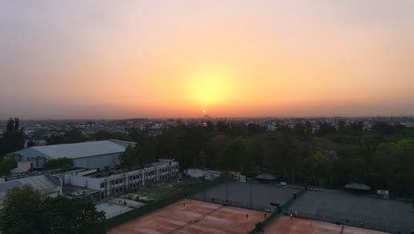 4K-Drone-Shots-of-a-Sunset-in-an-Indian-City-New-Delhi-above-trees-and-houses-beautiful-light-punjabi-bagh-club-posh-colony