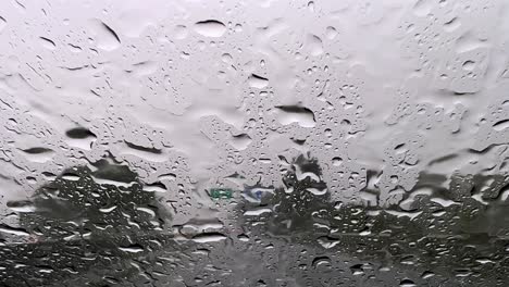 Raindrops-falling-over-windscreen-car-glass-while-driving-on-highway-with-wiper-cleaning