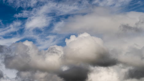 Wolkenzeitraffer-Mit-Weißer,-Flauschiger-Mischung-Mit-Dunklen,-Wütenden-Wolken,-Die-Am-Blauen-Himmel-Herumwirbeln