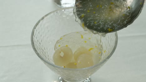 Pouring-Jelly-over-sweet-longan-fruit-in-a-dessert-cup