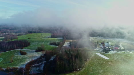 Luftaufnahme-Von-Nebel,-Der-über-Ein-Abgelegenes-Ländliches-Gehöft-Zieht,-Schneereste-Auf-Einer-Waldlandschaft