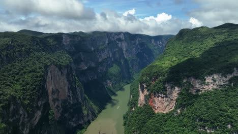 Tour-boat-on-the-Grijalva-river-in-the-Sumidero-Canyon-n-sunny-Chiapas,-Mexico---aerial-view
