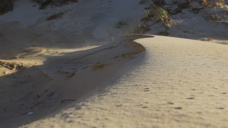 Sandstaub-Von-Sanddünen-Am-Meer,-Die-In-Der-Luft-Fließen,-Sandpartikel,-Die-Aufgrund-Des-Starken-Windes-Am-Strand-In-Der-Luft-Schweben,-Ostseeküste,-Küstenerosion,-Klimawandel,-Sonniger-Tag,-Nahaufnahme