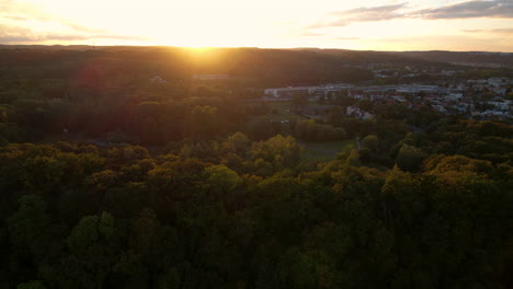 Charming-sunset---Gdynia-Kolibki---slow-backward-aerial-flight-over-the-treetops---yellowing-leaves-on-the-branches