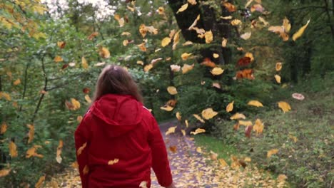 Frau-In-Roter-Jacke,-Die-Herbstblätter-In-Die-Luft-Wirft