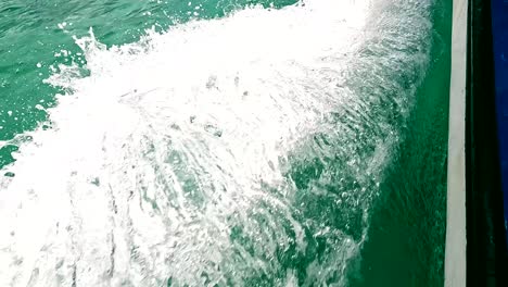 Track-shot-of-sea-foam-at-boat-side,-green-waters,-Indian-Ocean