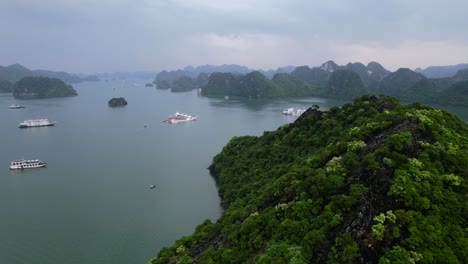 beautiful-landscape-of-tourists-on-boat-cruise-in-Ha-Long-Bay-Vietnam,-aerial