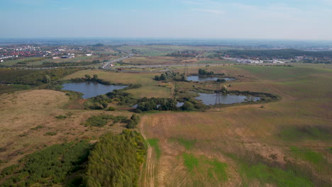 Small-bodies-of-water-located-in-a-huge-field-near-the-expressway---aerial-backward