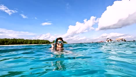 Happy-young-woman-with-diving-mask-on-swims-tropical-water-in-Mnemba-Island