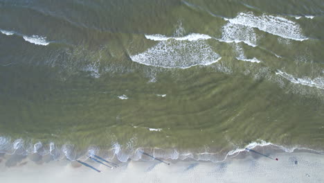 Aerial-Birds-Eye-View-Over-Waves-Gently-Breaking-On-Beach-At-Krynica-Morska