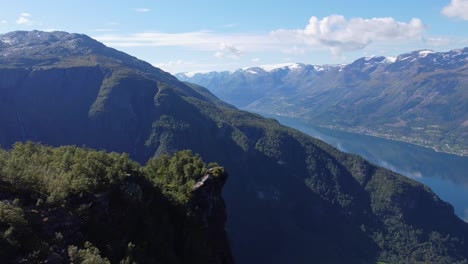 Aerial-moving-towards-Nosi-the-nose-viewpoint-above-Lofthus-in-Hardanger-Norway---Beautiful-sorfjorden-hardangerfjord-and-Folgefonna-glacier-in-background