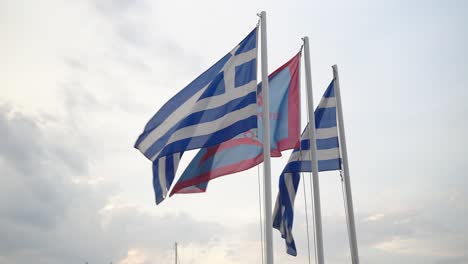 Flagge-Von-Spetses-Zwischen-Zwei-Griechischen-Nationalflaggen,-Die-In-Zeitlupe-Im-Wind-Wehen,-Mit-Himmel-Und-Wolken-Im-Hintergrund---Stabile-Kamera