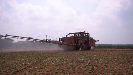 Asia-agricultural-treatment-of-insecticide-pesticide-to-land-farm-plantation-with-spray-machine-attached-to-tractor