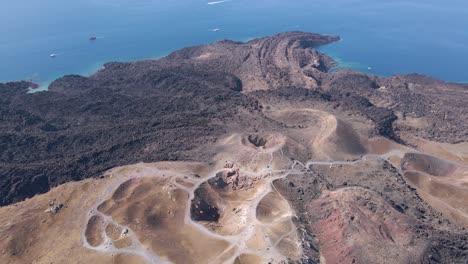 High-altitude-aerial-overview,-rotating-over-volcano-crater-at-Santorini-island,-Greece-in-slow-motion