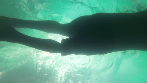 Man-Swimming-in-Pool-under-coconut-tree-resort-hotel-under-water-shot-slow-motion