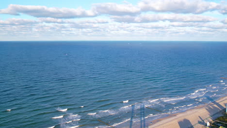 View-Of-Vast-Expanse-Of-The-Baltic-Sea-With-Aerial-Dolly-Back-Over-Beach-Coastline-At-Wladyslawowo