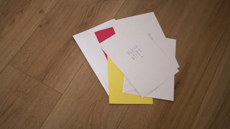 A-pile-of-unopened-letters-in-envelopes-on-a-wooden-floor